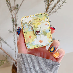 Gelbe Airpods-Hülle mit Blumenmuster