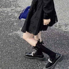 Zapatos de piel negros a juego con decoración de perlas