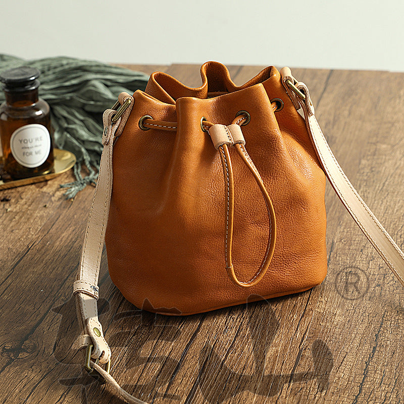 Bolso pequeño tipo cubo con cordón de curtido vegetal para mujer